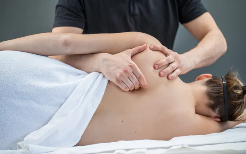 Massage therapist working on a client's shoulder area