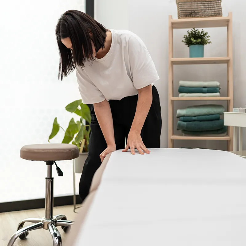 A massage therapist inspects her massage table.